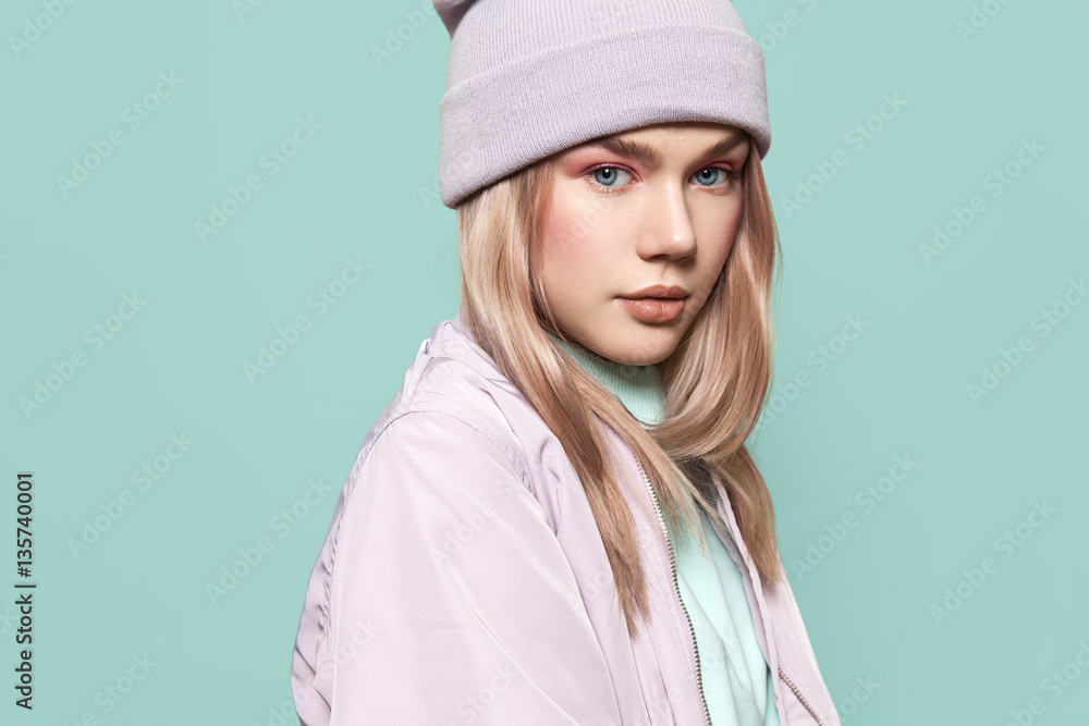 Portrait of a beautiful girl standing on a blue background in a blue sweatshirt Portrait of a beautiful girl standing on a blue background in a blue sweatshirt