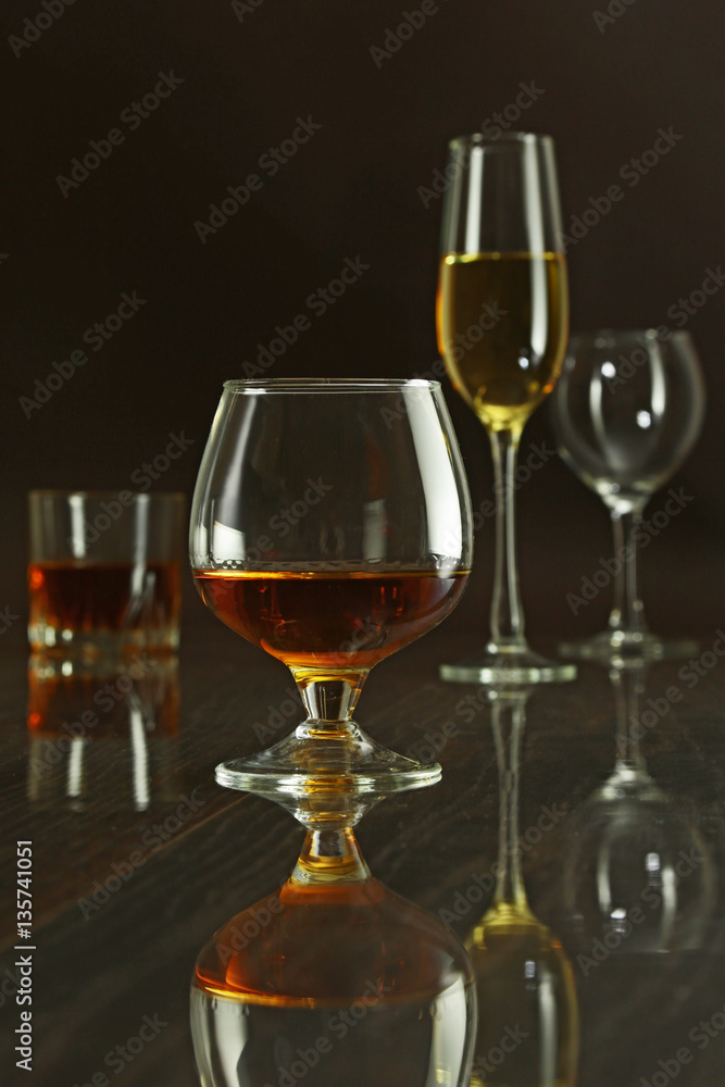 Glasses with white, red wine and cognac or whisky on mirror table. Celebrities composition. Glasses with white, red wine and cognac or whisky on mirror table. Celebrities composition.