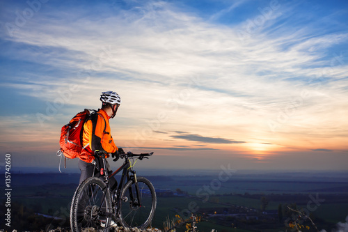 cyclist on mountain-bike background of beautiful sunset.