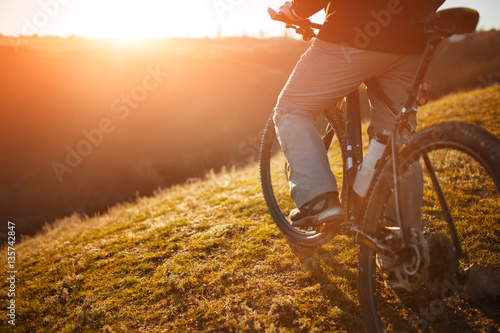 cyclist stand with mountain bike at sunset