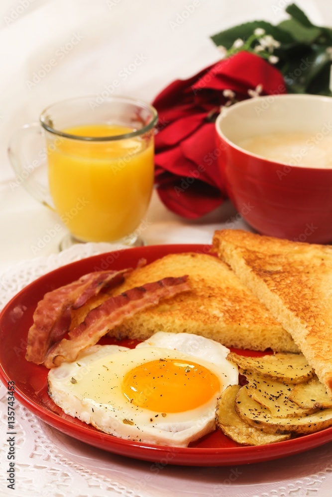 Valentine breakfast with heart shaped egg bacon bread toast cup of coffee served in red plate