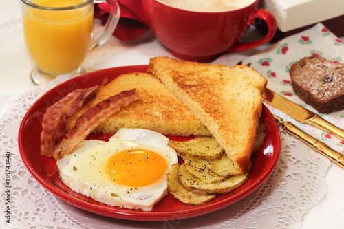 Valentine breakfast with heart shaped egg bacon bread toast cup of coffee served in red plate