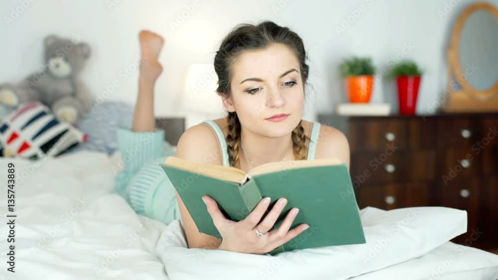 Girl in pyjamas finishes reading book and looks very happy
Girl in pyjamas finishes reading book and looks very happy