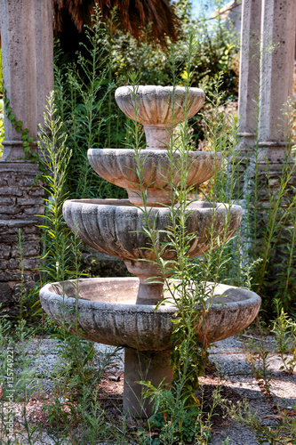 Old stone decorative fountain in the abandoned garden