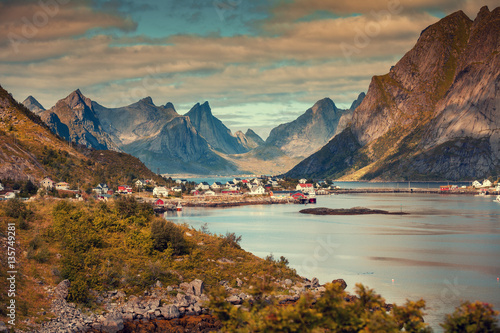 Panoramic view of the fishing village of Reine with dramatic sky. Rocky beach, Lofoten islands, Norway