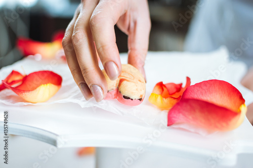 Fotografija Pastry-cook puts prepared candies in the form of hearts on tray