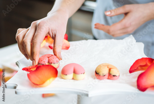 фотографія Pastry-cook puts prepared candies in the form of hearts on tray
