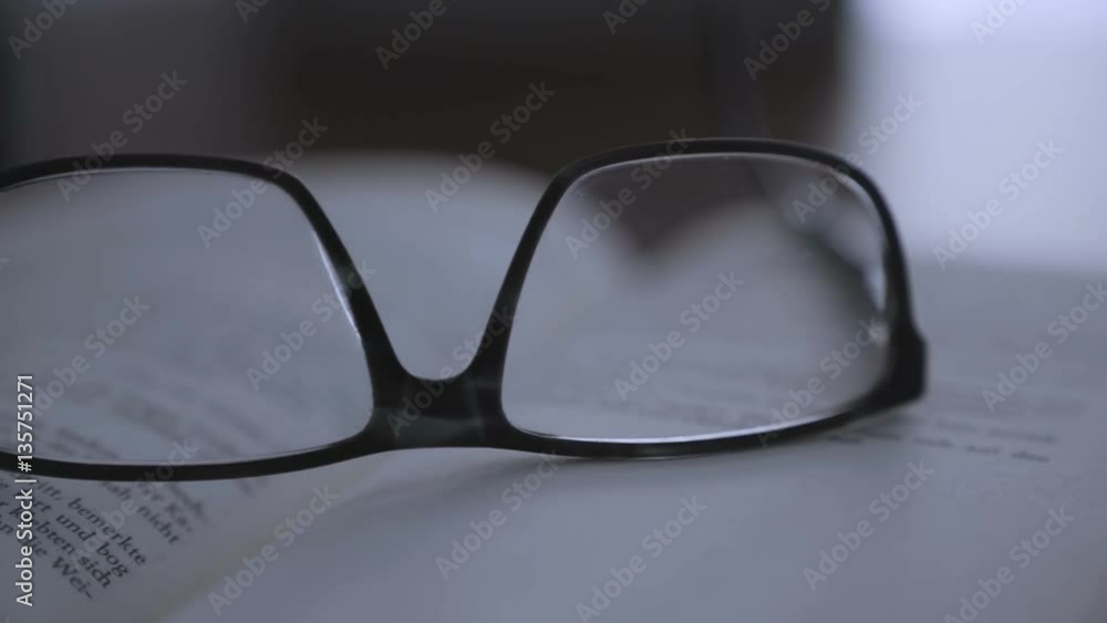 old books on desktop with modern glasses on open pages - vintage film style, smooth tracking shot old books on desktop with modern glasses on open pages - vintage film style, smooth tracking shot