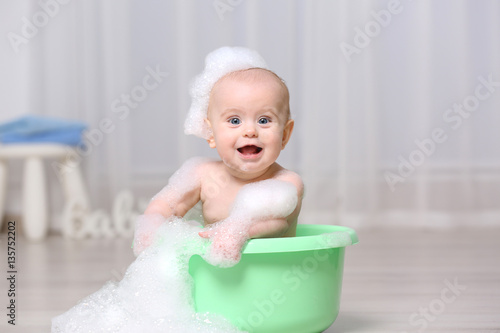 Cute baby washing in plasti...