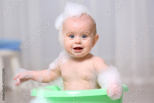 Cute baby washing in plasti...