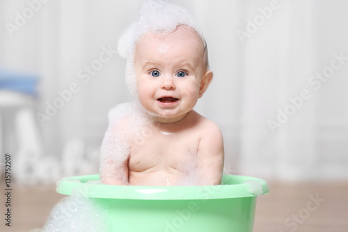 Cute baby washing in plasti...