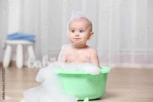 Cute baby washing in plasti...