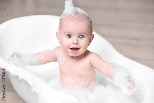 Cute baby washing in bathtu...