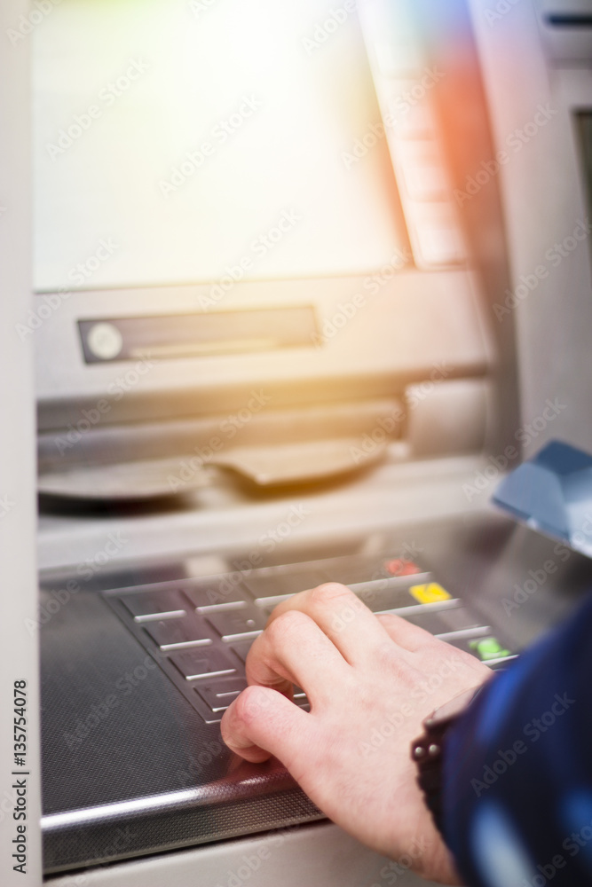Hand of a man with a credit card, using an ATM. Man using an atm machine with his credit card. Hand of a man with a credit card, using an ATM. Man using an atm machine with his credit card.