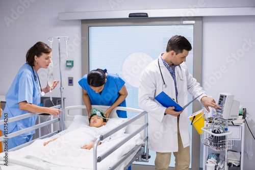 Doctors examining patient in ward 