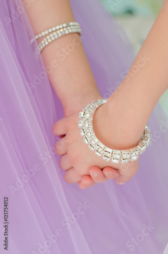 Hands with bridesmaids to wear bracelets of precious stones closeup