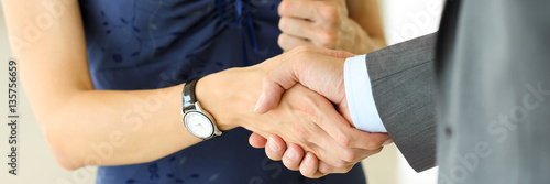 Stampa su tela Businessman and woman shake hands as hello in office closeup