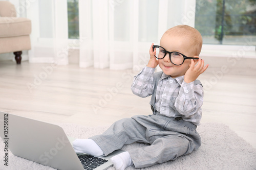Cute baby boy with laptop o...