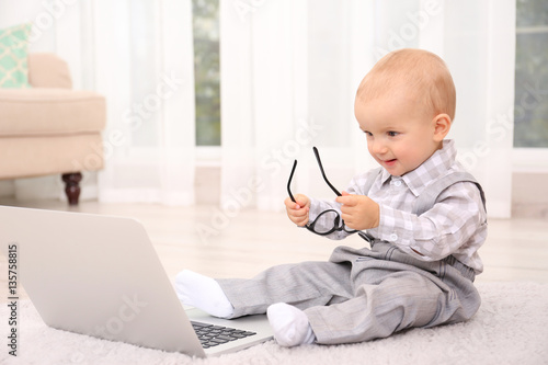 Cute baby boy with laptop o...