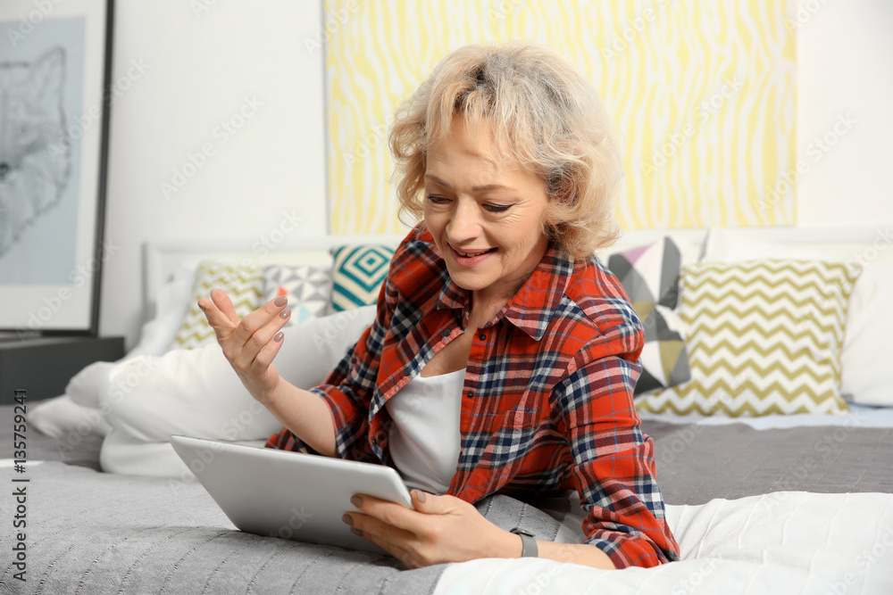 Senior woman making video call from tablet computer at home Senior woman making video call from tablet computer at home