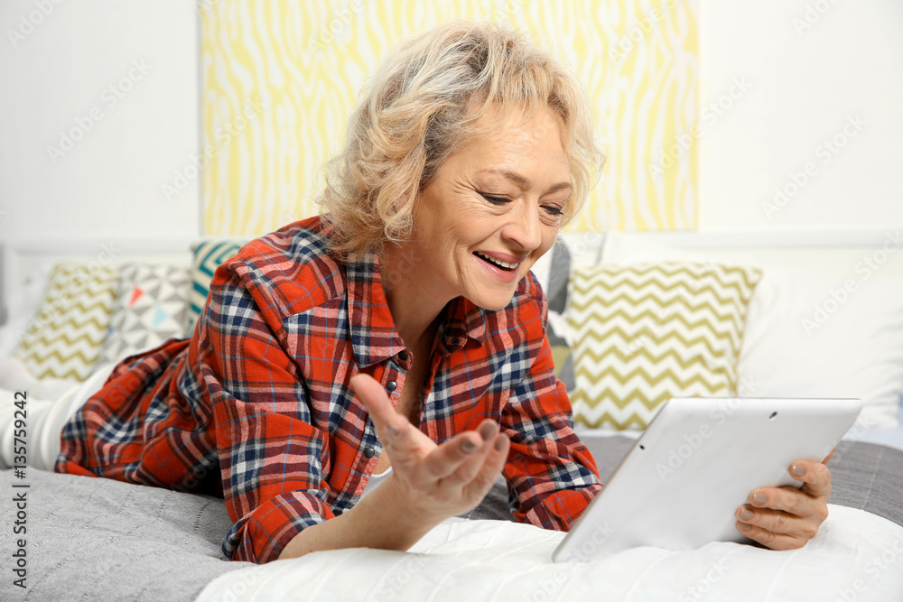 Senior woman making video call from tablet computer at home Senior woman making video call from tablet computer at home