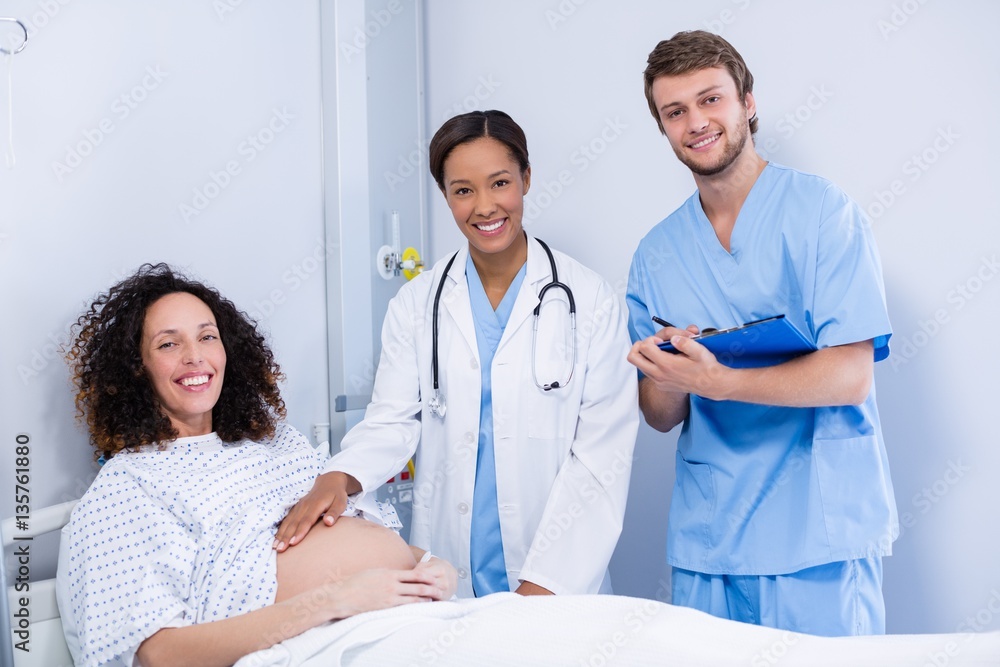 Portrait of doctors examining pregnant woman in ward Portrait of doctors examining pregnant woman in ward