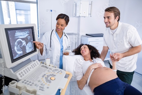 Doctor doing ultrasound scan for pregnant woman