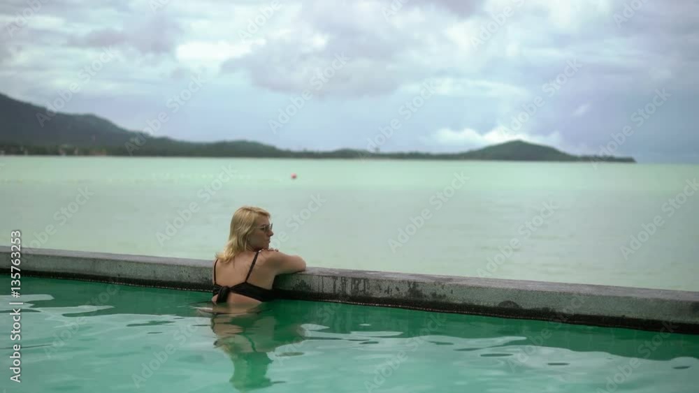 Woman relaxing in pool in resort