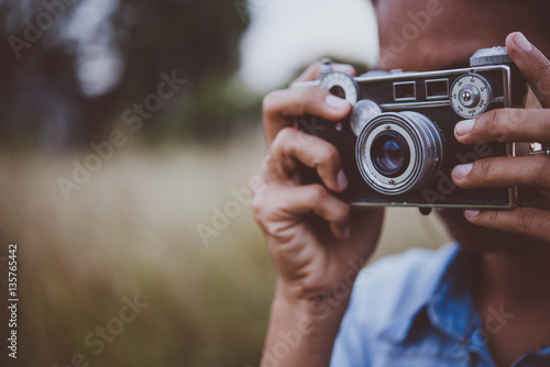 Young hipster woman took photo by vintage camera.
