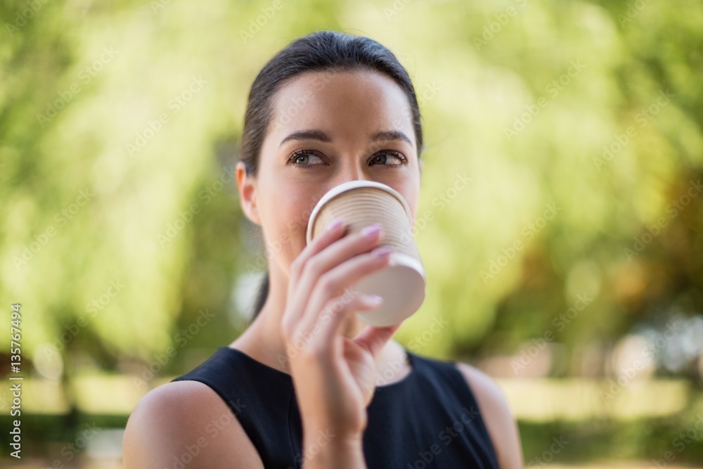 Beautiful woman drinking coffee from disposable cup Beautiful woman drinking coffee from disposable cup