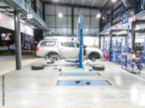 interior of garage with car repairs on a lift - blurred for background