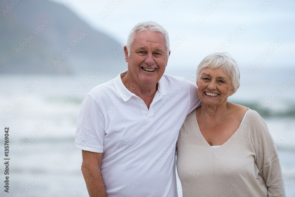 Portrait of senior couple standing together at beach