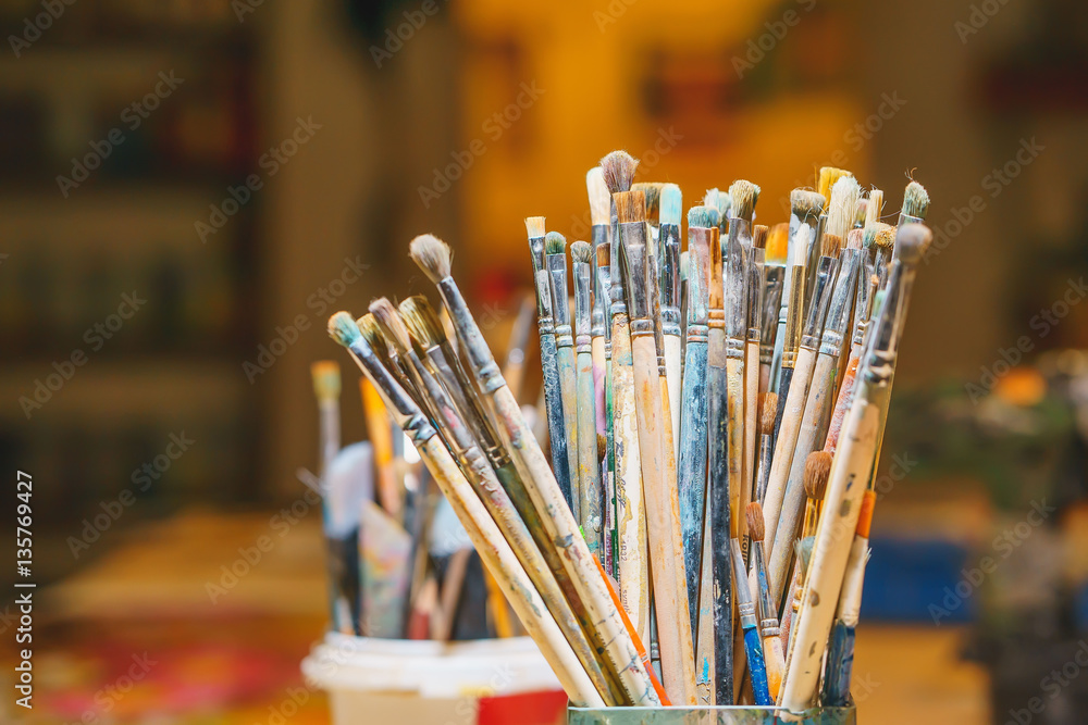 Paint Brushes isolated in colorful background, close-up Paint Brushes isolated in colorful background, close-up
