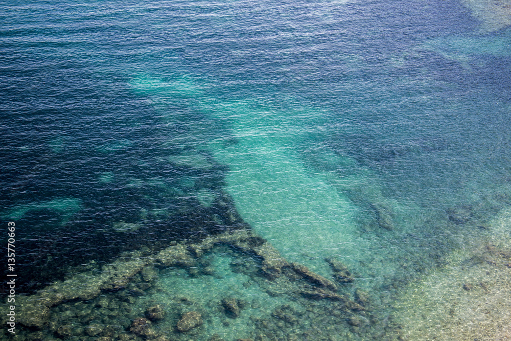 Turquoise sea with rocky bottom