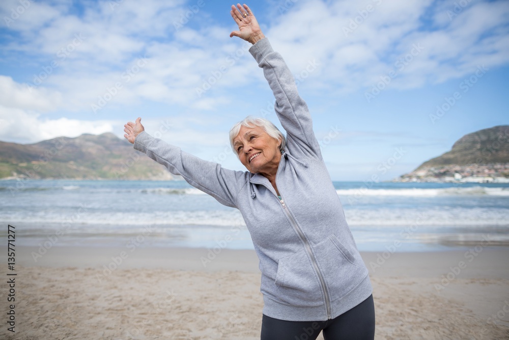 Senior woman doing stretching exercise on the beach Senior woman doing stretching exercise on the beach