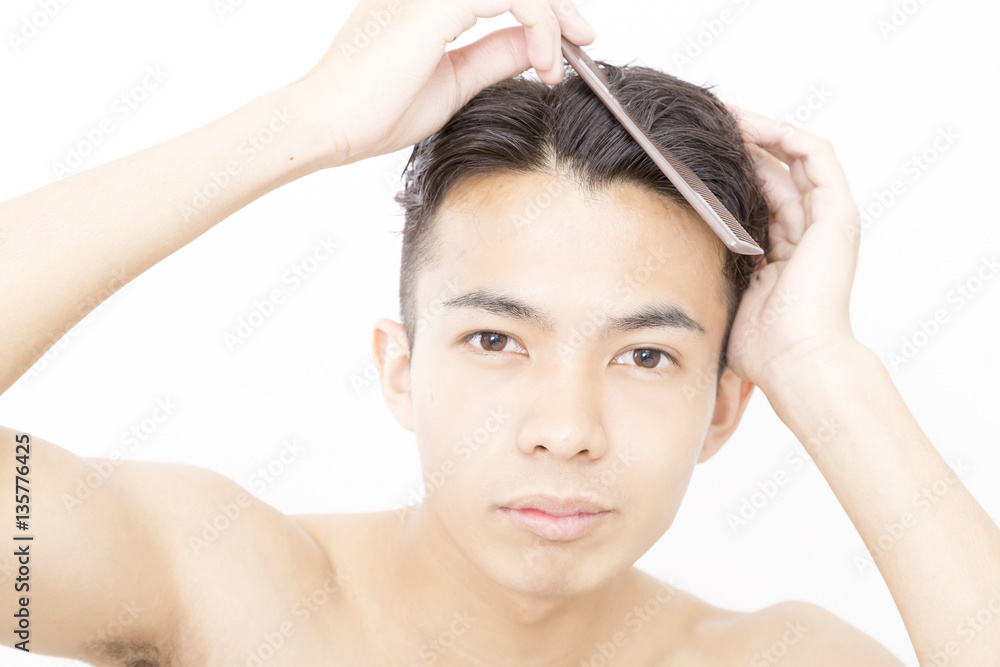 Naklejka premium メンズビューティ 整髪 ヘアースタイルを整える 寝ぐせ直し アップ カメラ目線 白バック