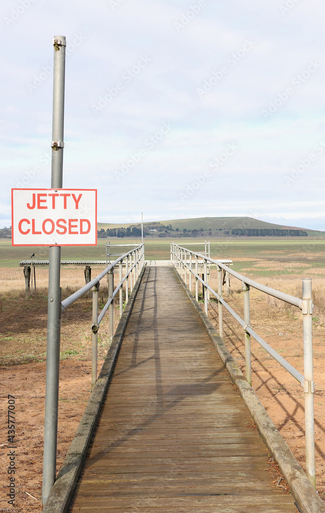 dried out lake bed with Jetty closed sign