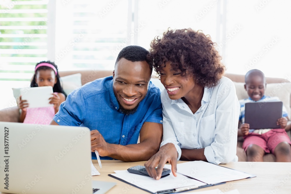Couple sitting at table and calculating bills Couple sitting at table and calculating bills