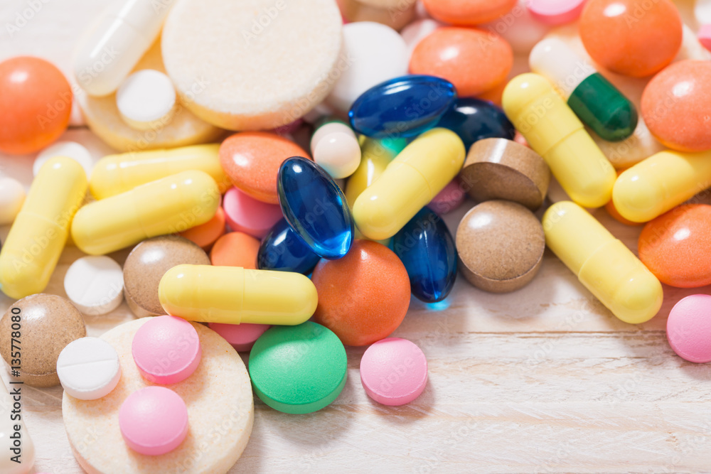 different pills mix on white wooden background different pills mix on white wooden background