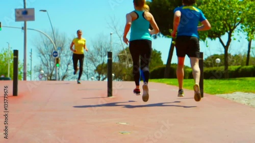 Joggers passing each other while running, steadycam shot, slow motion shot
