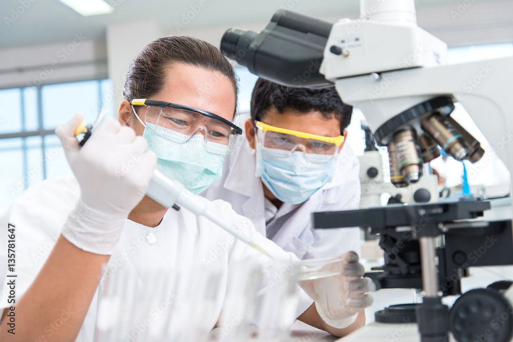 scientists male and female with equipment and science experiment scientists male and female with equipment and science experiment