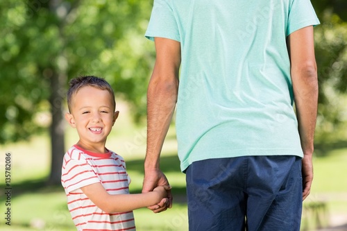 Son holding hands of his father in park © WavebreakMediaMicro