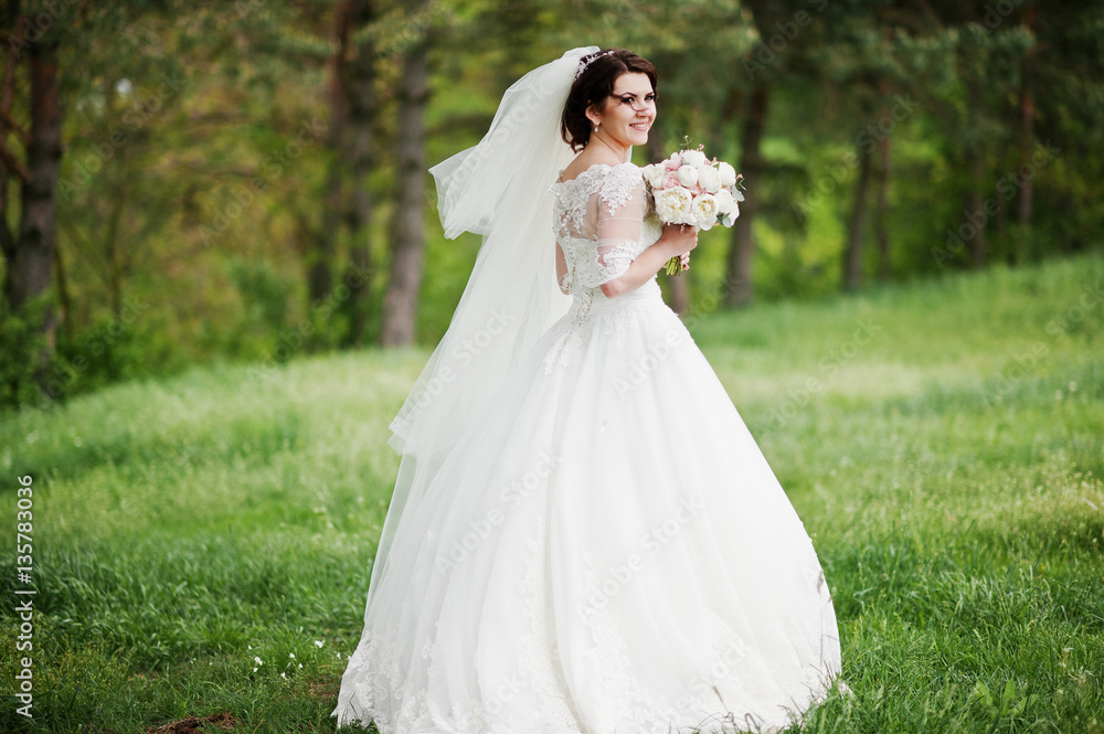 Tenderness brunette bride with wedding bouquet at hand walking o Tenderness brunette bride with wedding bouquet at hand walking o
