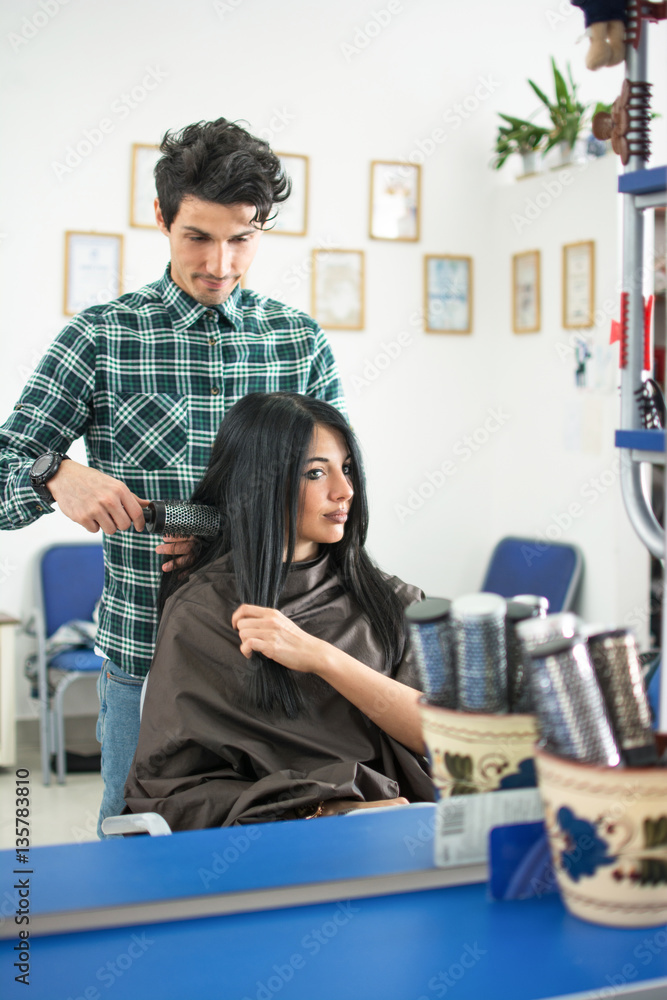 Mirror reflection of professional hairdresser working in the hairdressing salon. Mirror reflection of professional hairdresser working in the hairdressing salon.