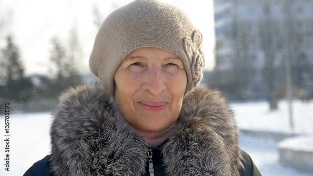 portrait aged smiling woman outdoors, winter time, slow motion portrait aged smiling woman outdoors, winter time, slow motion