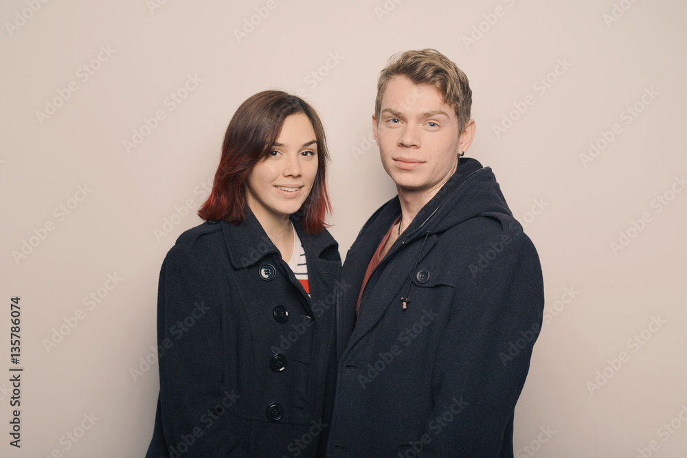 Happy young couple in winter clothes having fun in studio over white background Happy young couple in winter clothes having fun in studio over white background