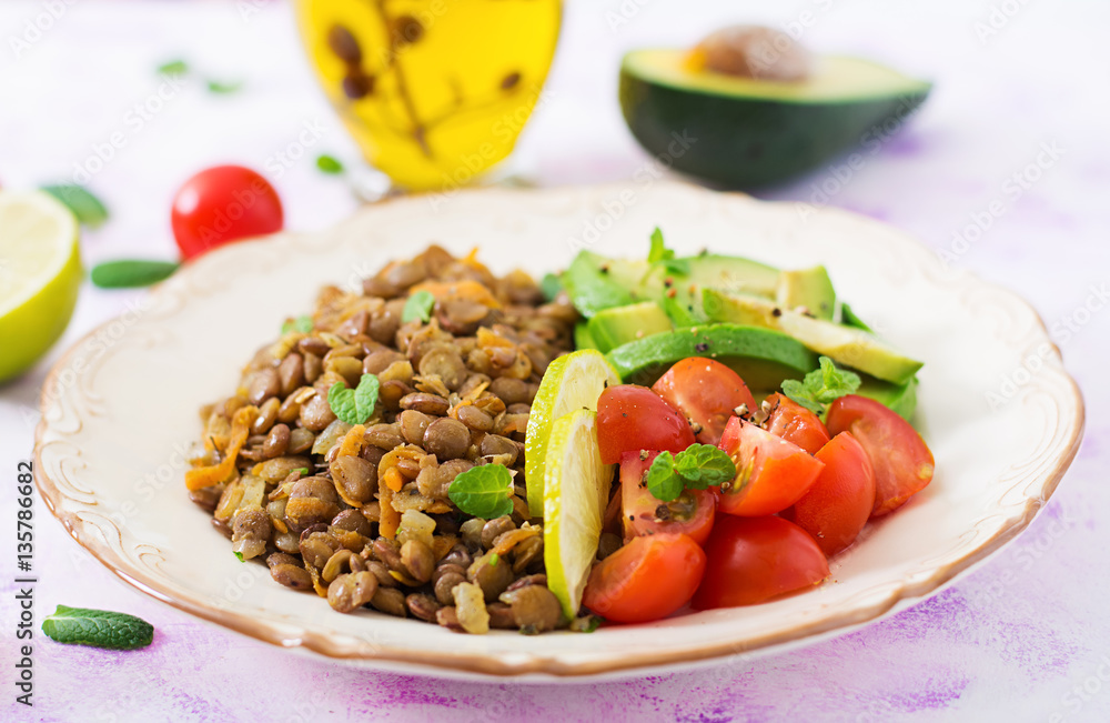 Diet menu. Healthy lifestyle. Lentils porridge and fresh vegetables - tomatoes and avocado on plate. Diet menu. Healthy lifestyle. Lentils porridge and fresh vegetables - tomatoes and avocado on plate.