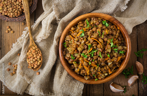 Lentil with carrot and onion in wooden bowl. Healthy lifestyle. Diet menu. Flat lay. Top view