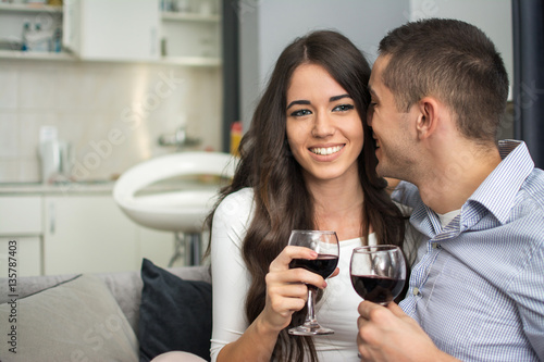 Happy young couple drinking wine at home. © Bojan