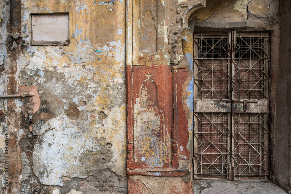 Gated door way in dilapidated wall in Delhi